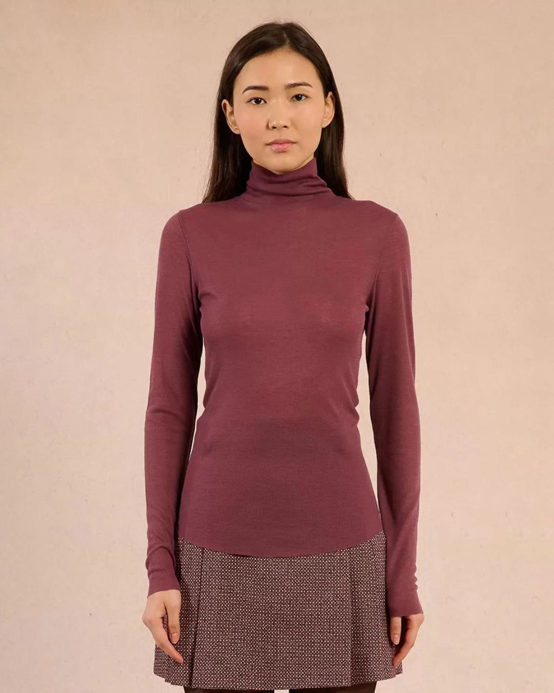 Woman wearing a rust coloured turtleneck sweater