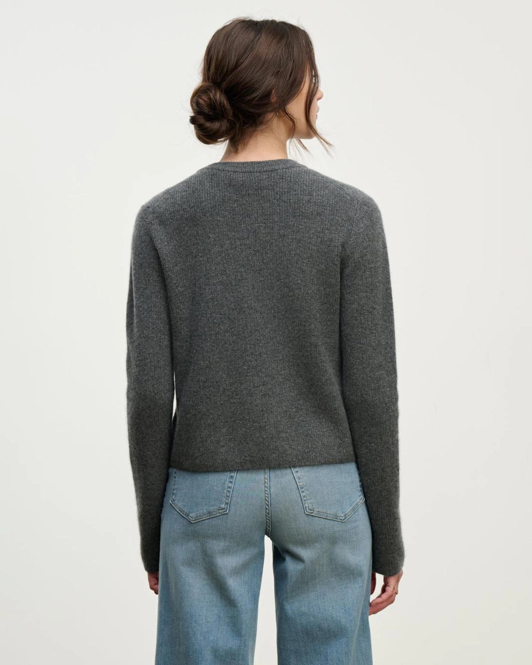 a woman wears a cashmere cardigan sweater in grey with a single button at the collar