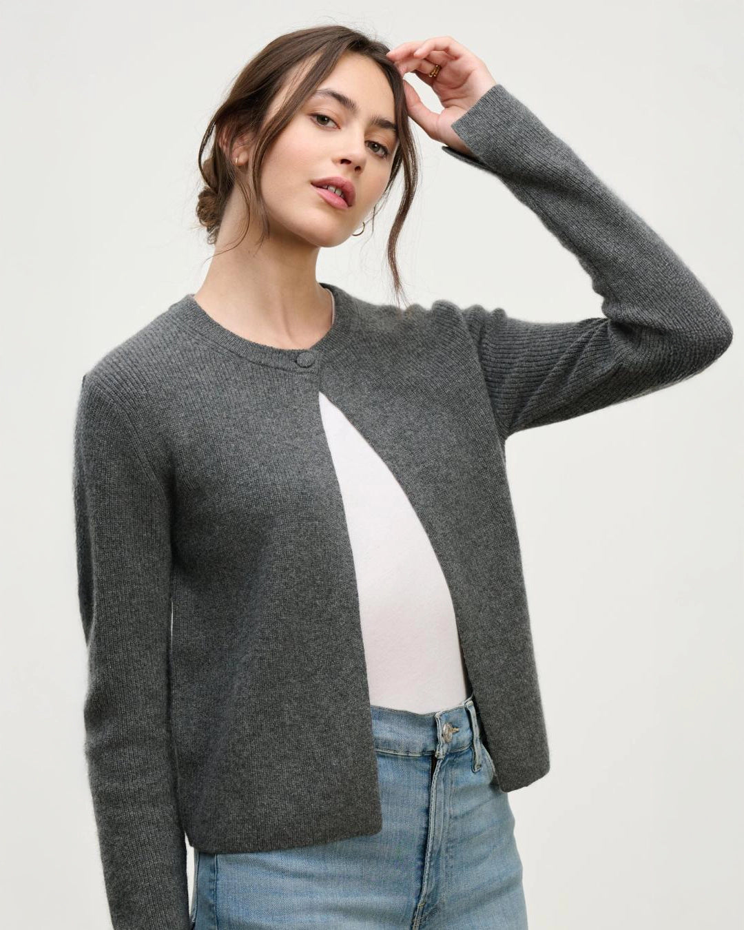 a woman wears a cashmere cardigan sweater in grey with a single button at the collar