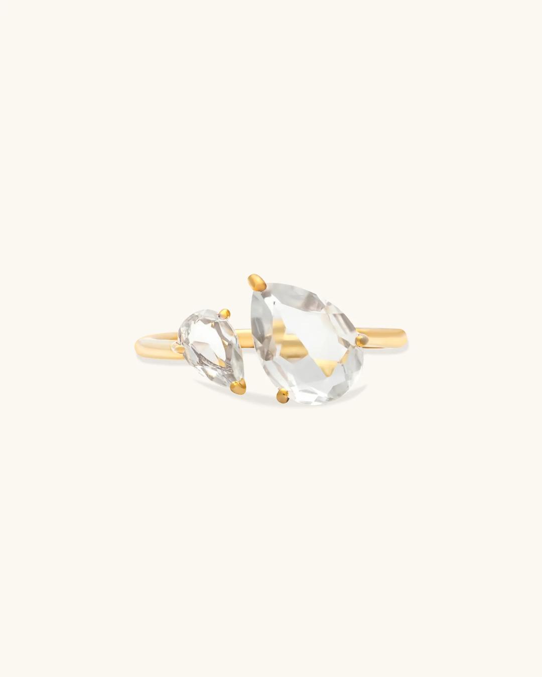 gold ring with a large diamond on one side and a little one beside it