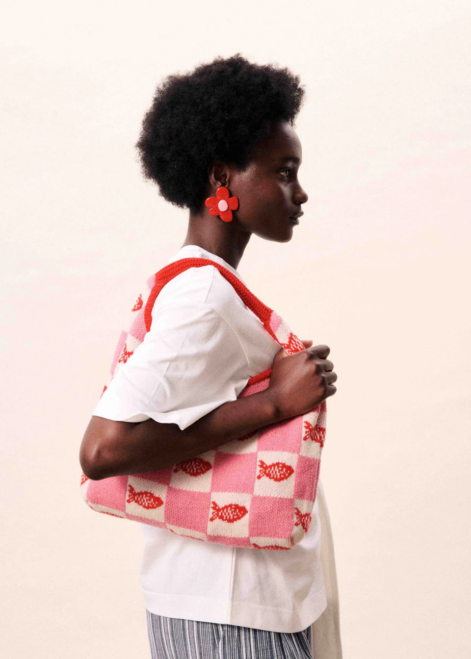 pink and white checkered hand bag with red fish on it