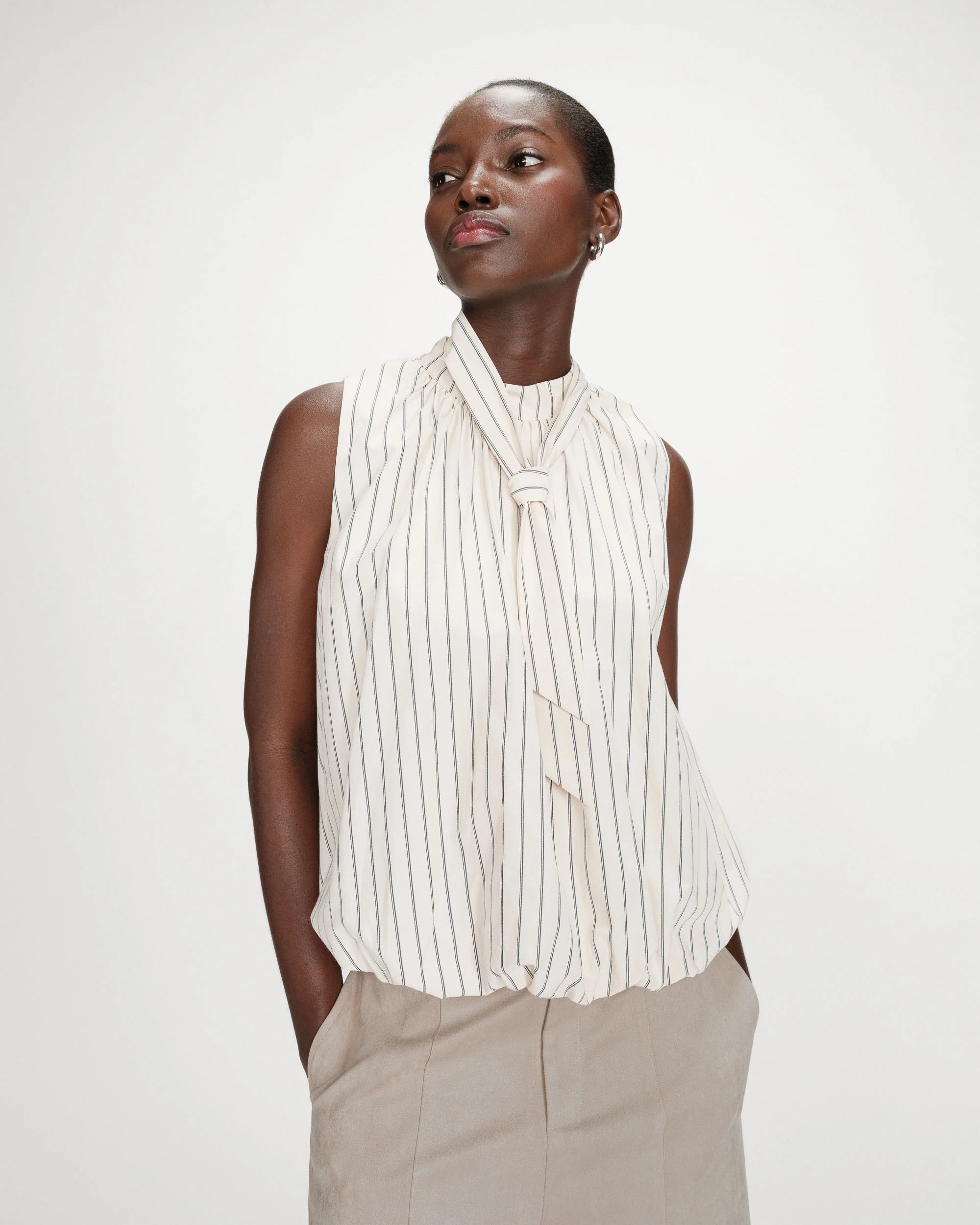 sleeveless top with bubble bottom and a tie at the neck in cream