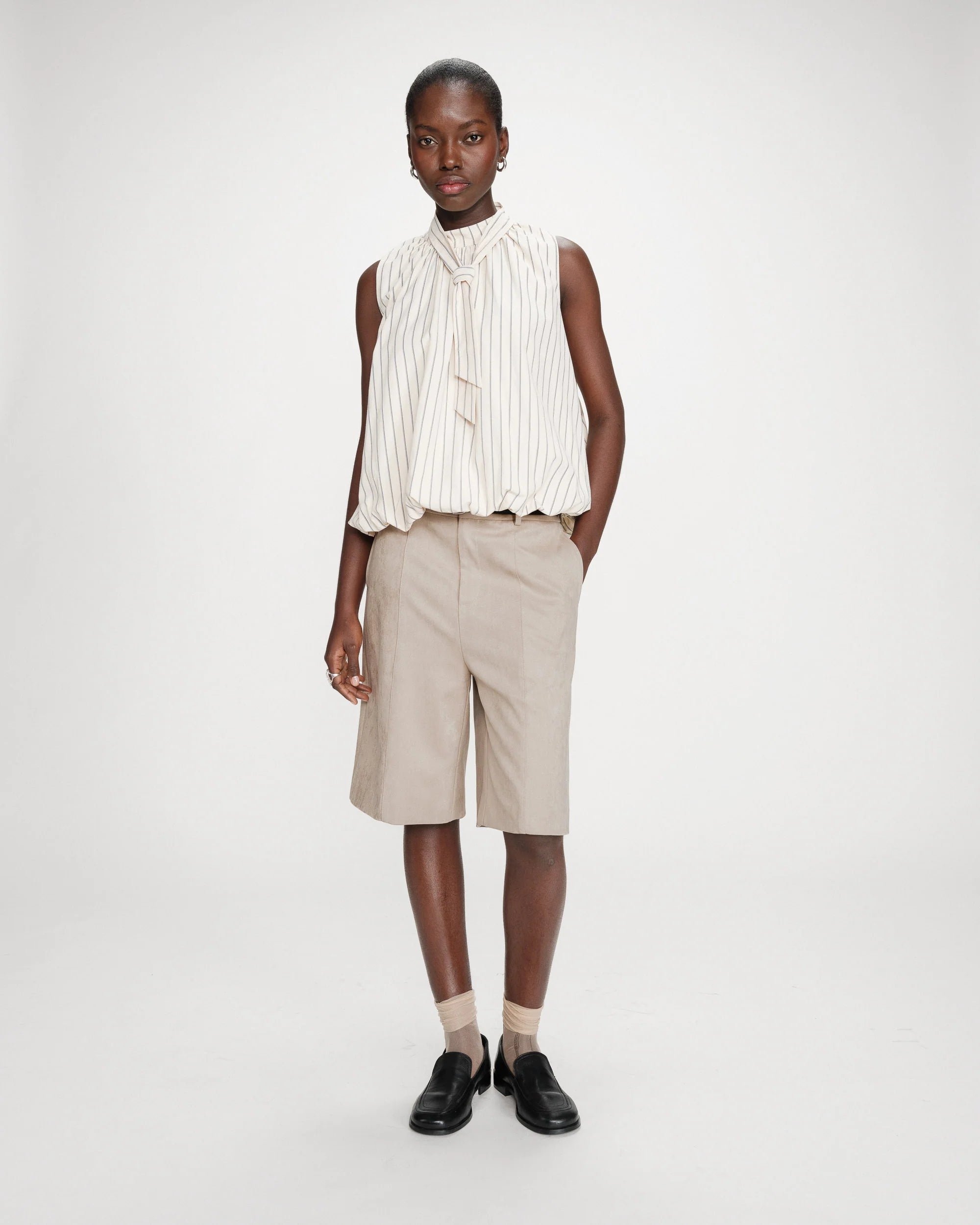 sleeveless top with bubble bottom and a tie at the neck in cream