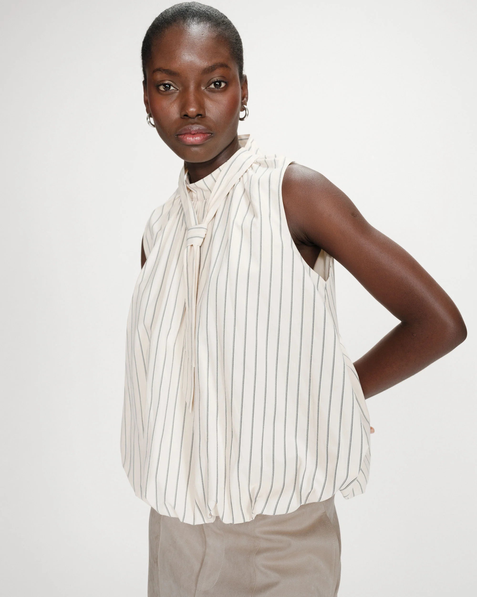 sleeveless top with bubble bottom and a tie at the neck in cream