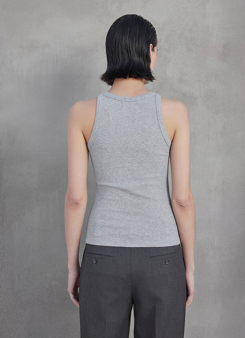 A woman wearing a grey ribbed tank top and grey trousers