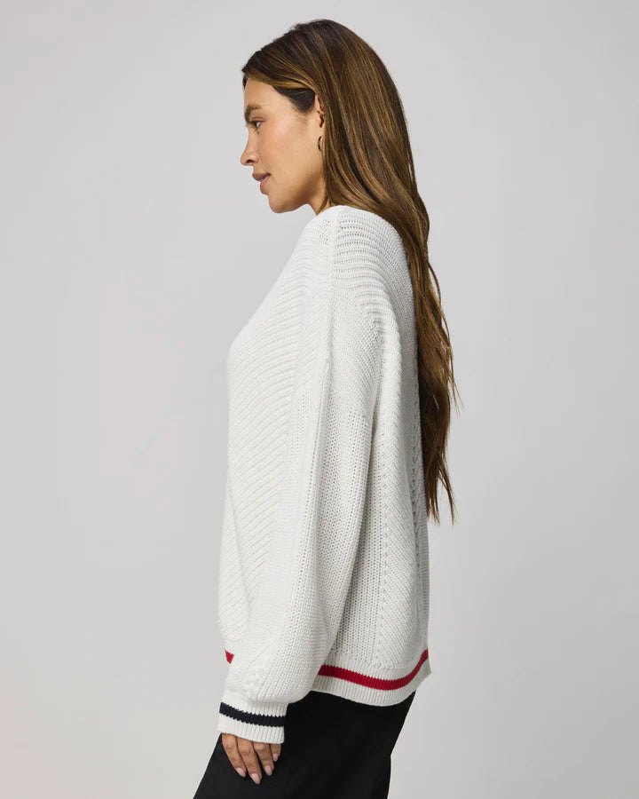 white sweater with navy at the collar and red at the bottom