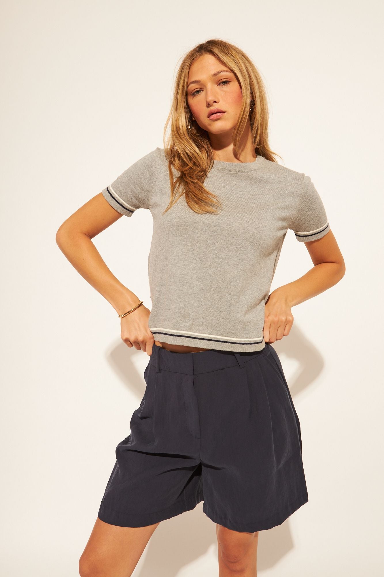 grey t-shirt with a black and white stripe on sleeves and bottom