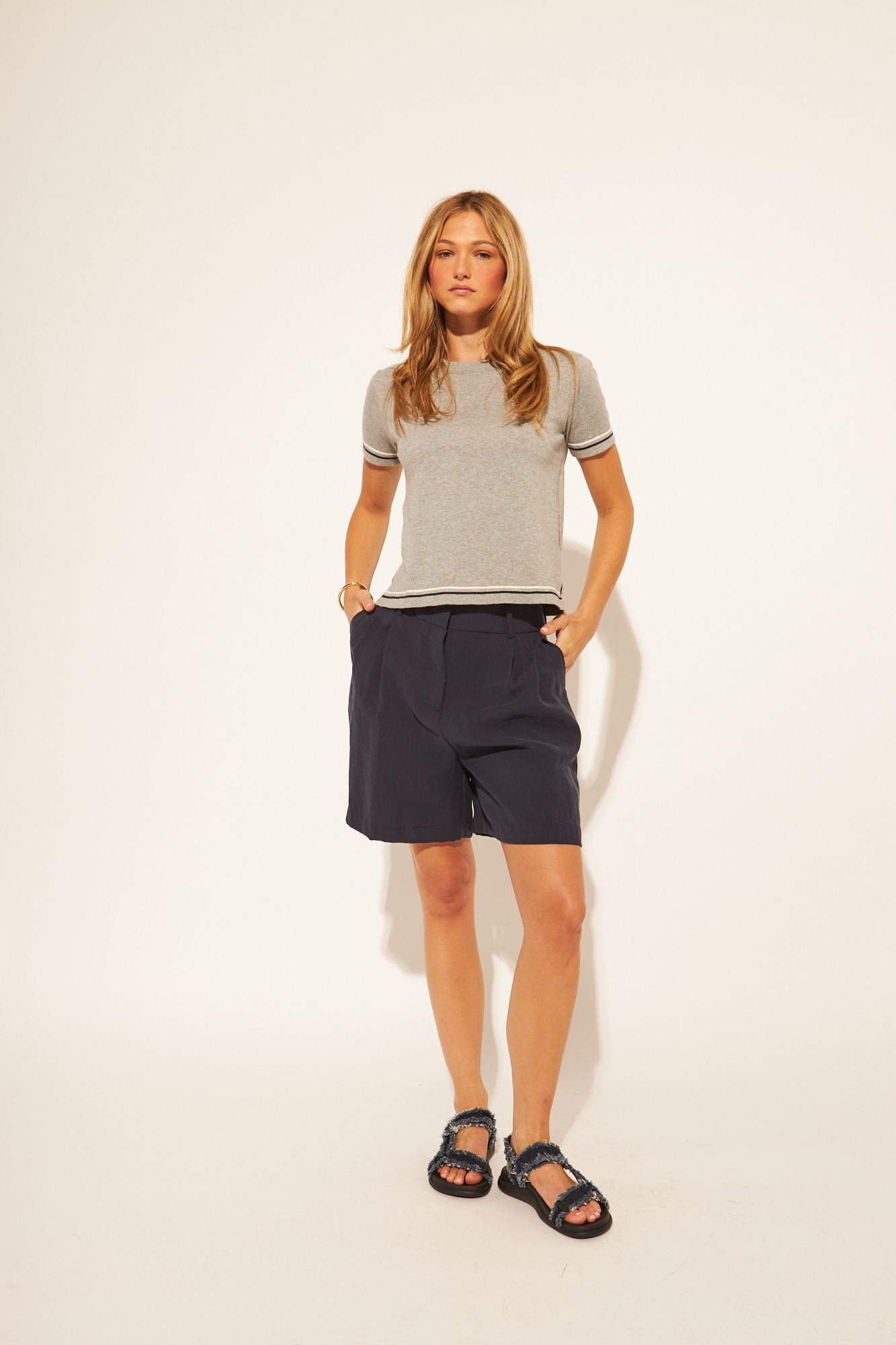 grey t-shirt with a black and white stripe on sleeves and bottom