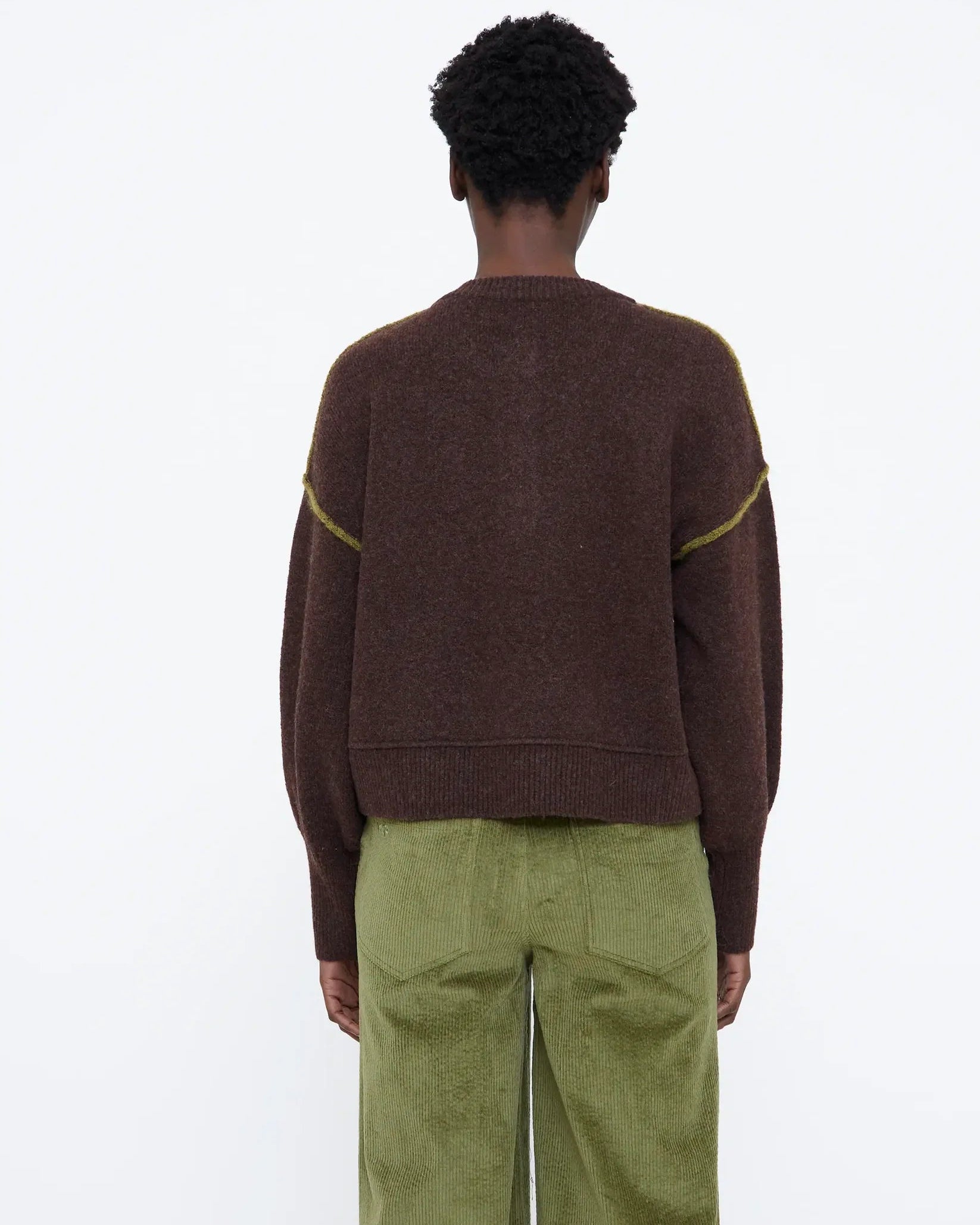 brown knit sweater with buttons half down and a green detail on sleeve