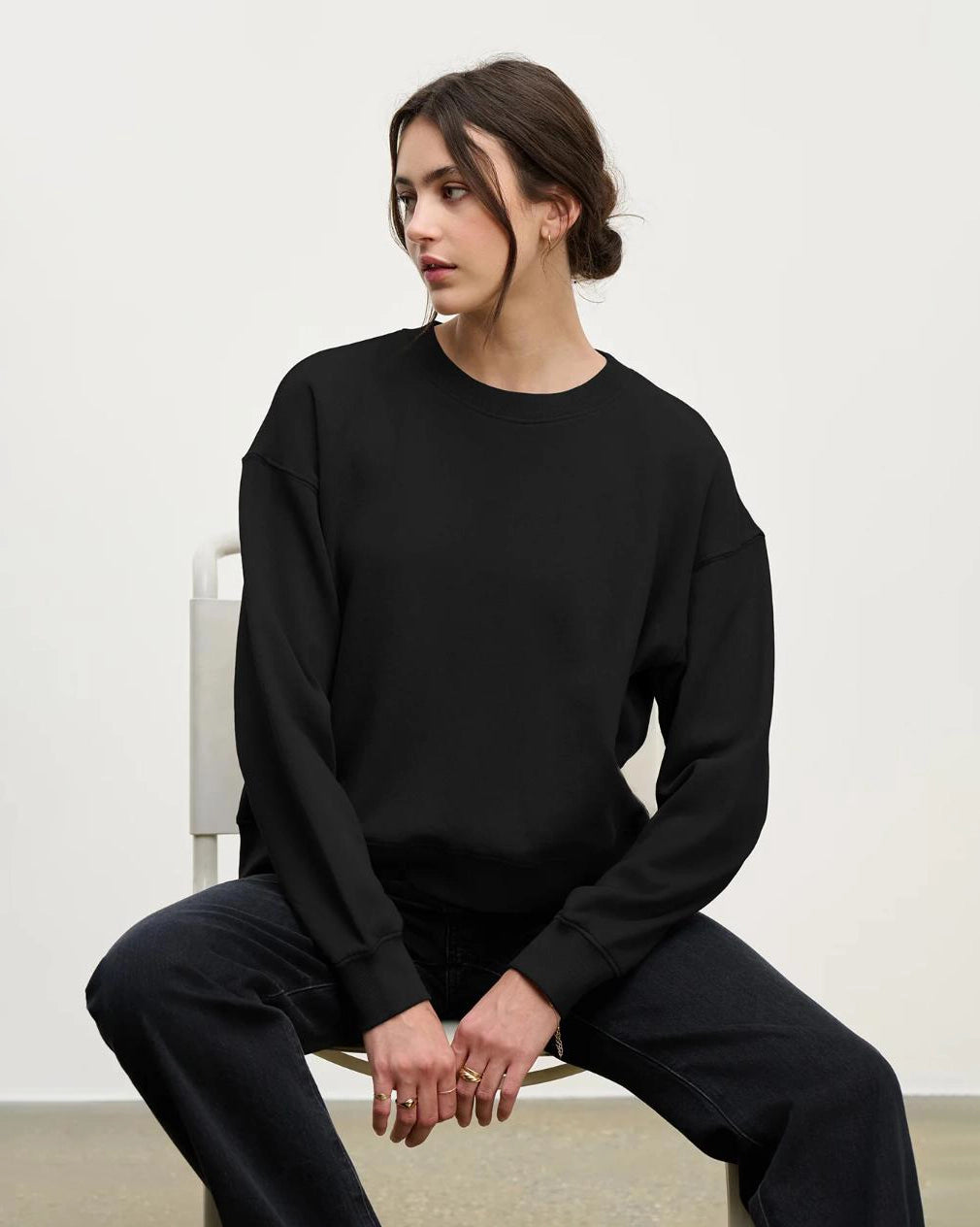 a woman wearing a cotton crew neck sweater in black