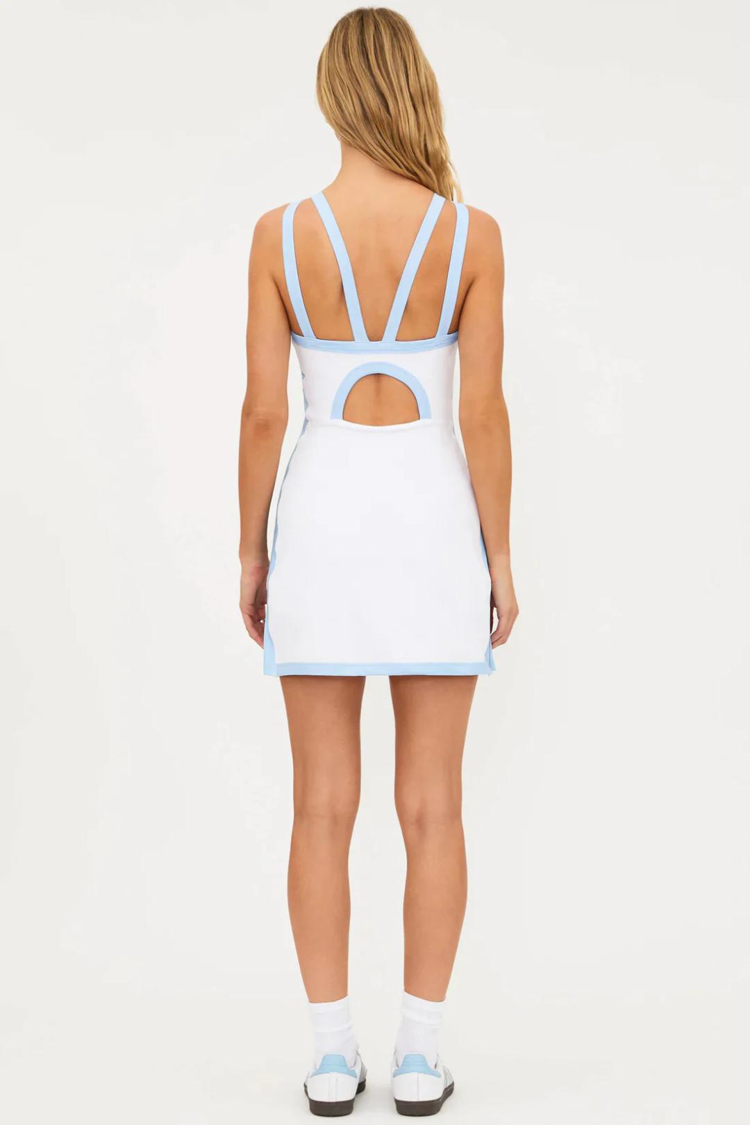Woman wearing a white tennis dress with blue trim