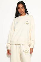 crew neck sweater in cream with a butterfly and 222 written on the sides