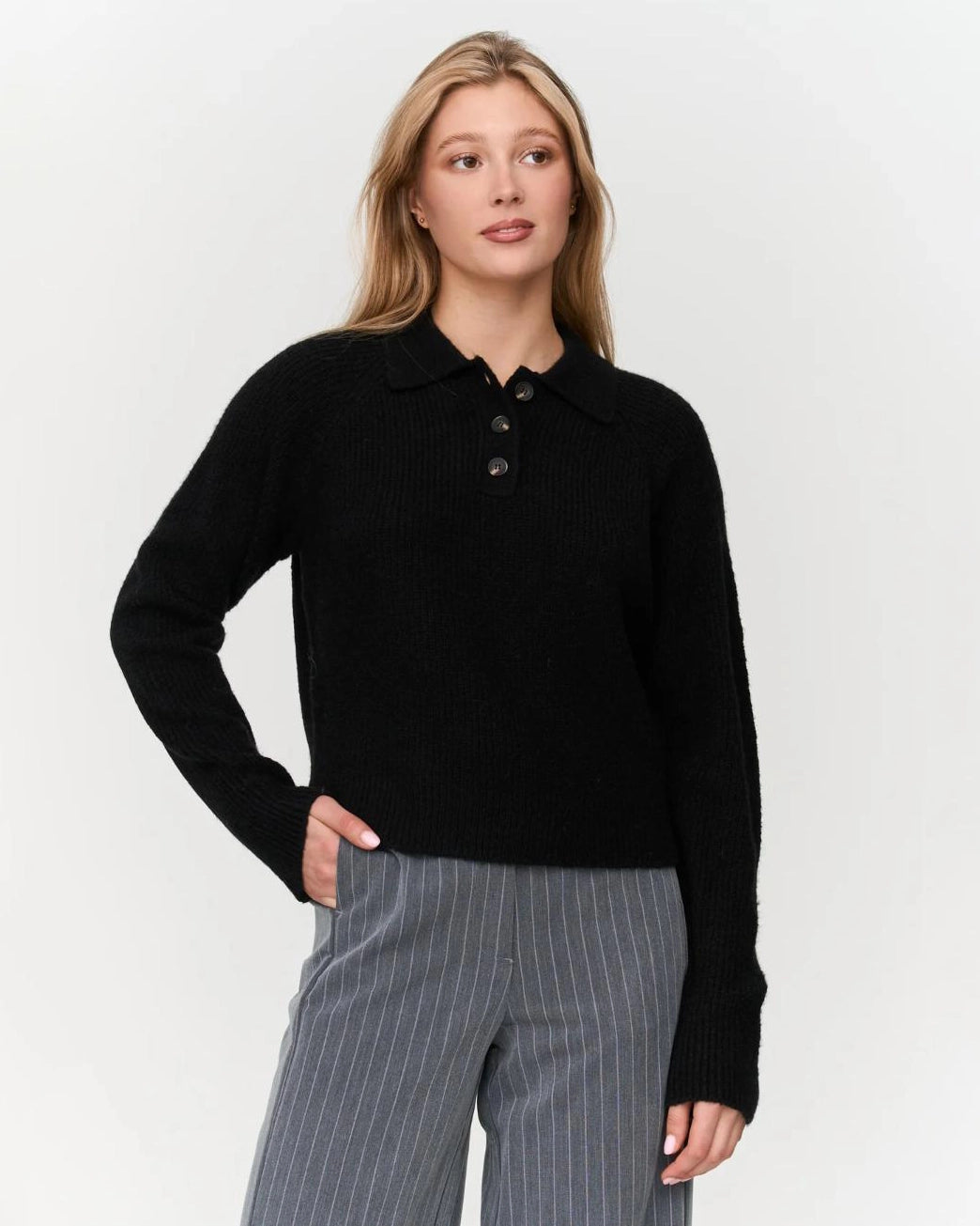 a woman wears a black ribbed knit polo sweater
