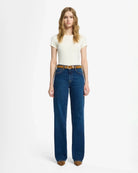 A woman wearing blue mid rise jeans by 7 For All Mankind