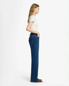 A woman wearing blue mid rise jeans by 7 For All Mankind