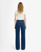 A woman wearing blue mid rise jeans by 7 For All Mankind