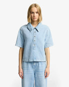 Woman wearing a light blue denim shirt and pants