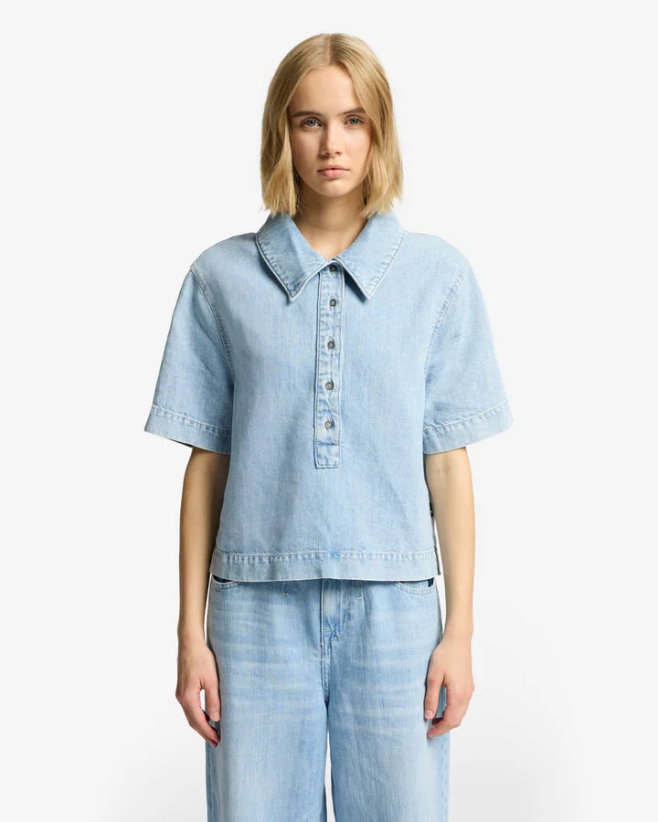 Woman wearing a light blue denim shirt and pants