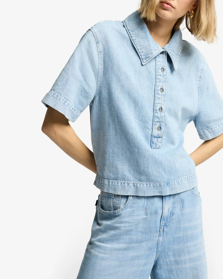 Woman wearing a light blue denim shirt and pants