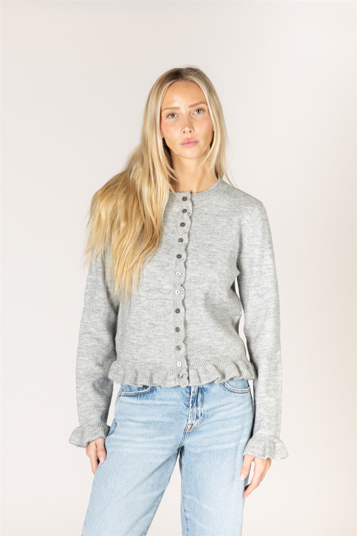 grey cardigan with ruffles down the middle and on sleeves