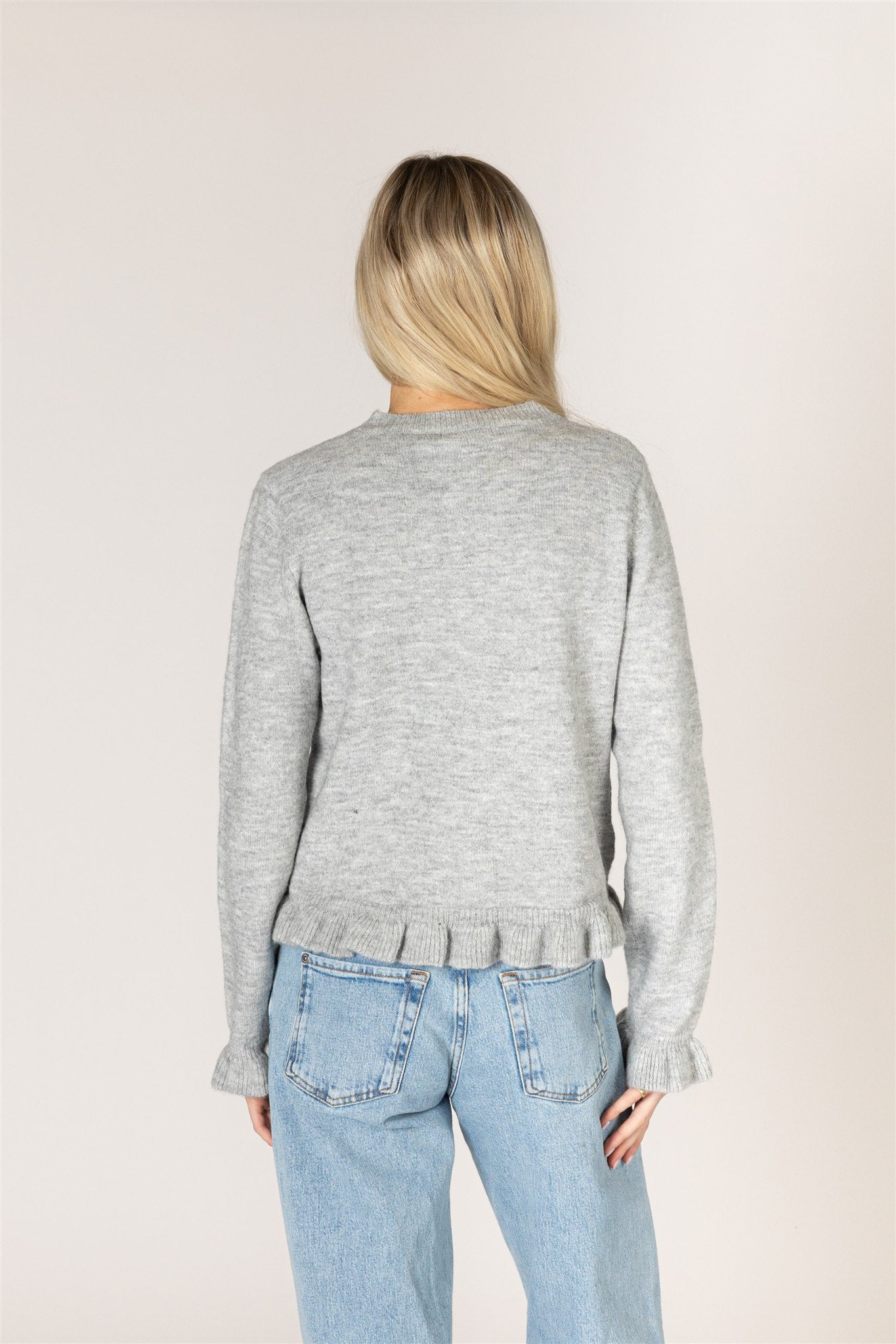 grey cardigan with ruffles down the middle and on sleeves