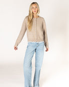beige knit cardigan with pearl buttons and lace trim on the bottom