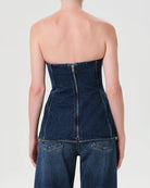 Woman wearing a denim strapless corset top by Agolde