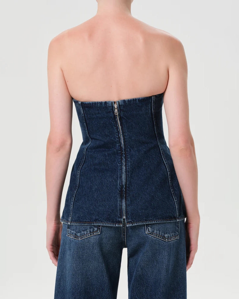 Woman wearing a denim strapless corset top by Agolde