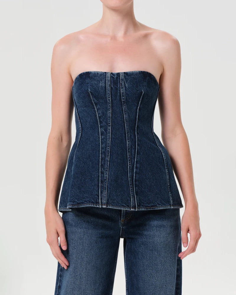 Woman wearing a denim strapless corset top by Agolde