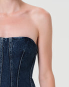 Woman wearing a denim strapless corset top by Agolde