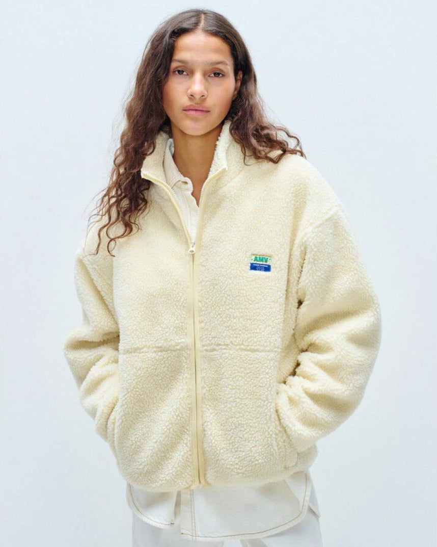 Person wearing a yellow colored fleece jacket with american vintage logo