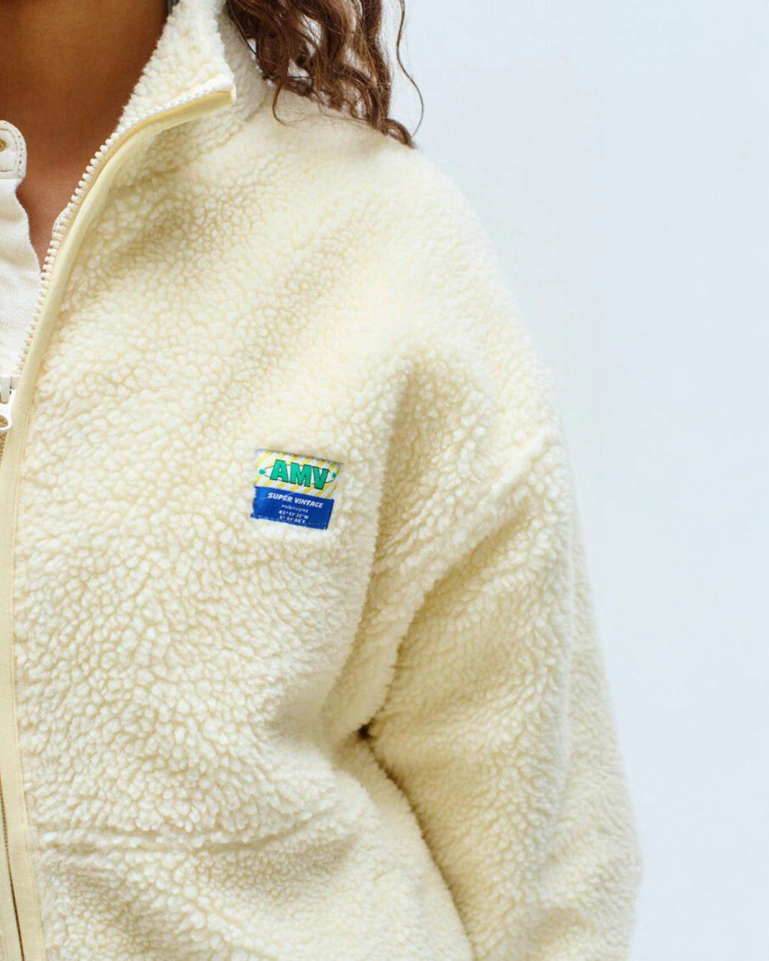 Person wearing a yellow colored fleece jacket with american vintage logo