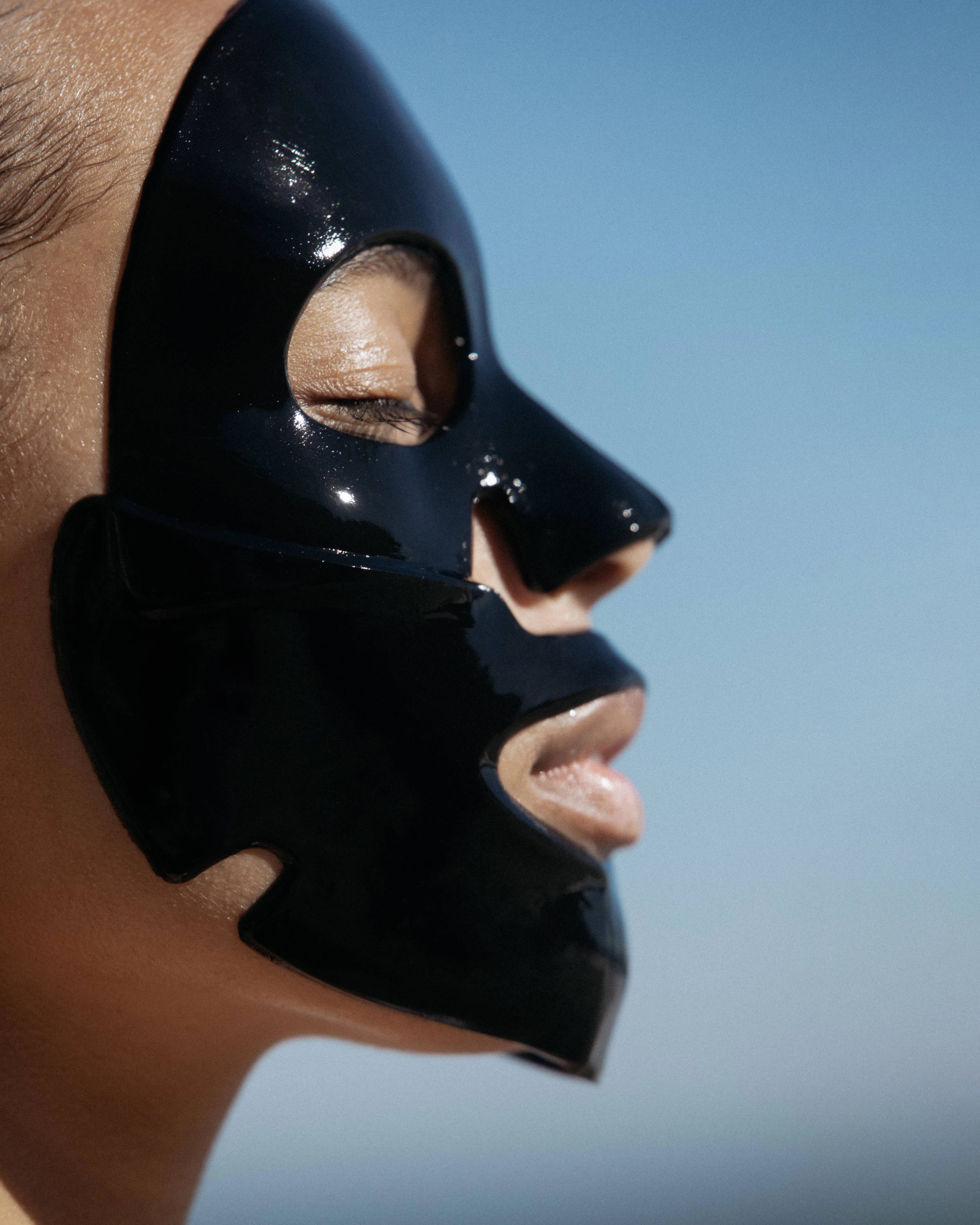 person wearing a black collagen face mask