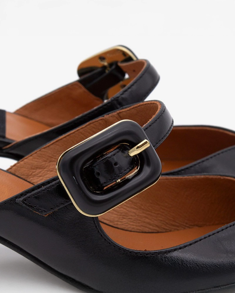 pointed toe mule with an open back and a small heel. Has a strap across the foot that has a black buckle on it