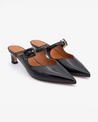 pointed toe mule with an open back and a small heel. Has a strap across the foot that has a black buckle on it