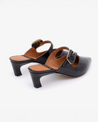 pointed toe mule with an open back and a small heel. Has a strap across the foot that has a black buckle on it
