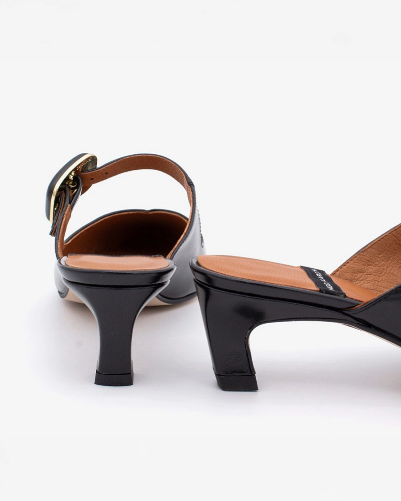 pointed toe mule with an open back and a small heel. Has a strap across the foot that has a black buckle on it
