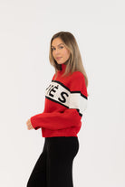 red sweater with whit and black stripe saying apres