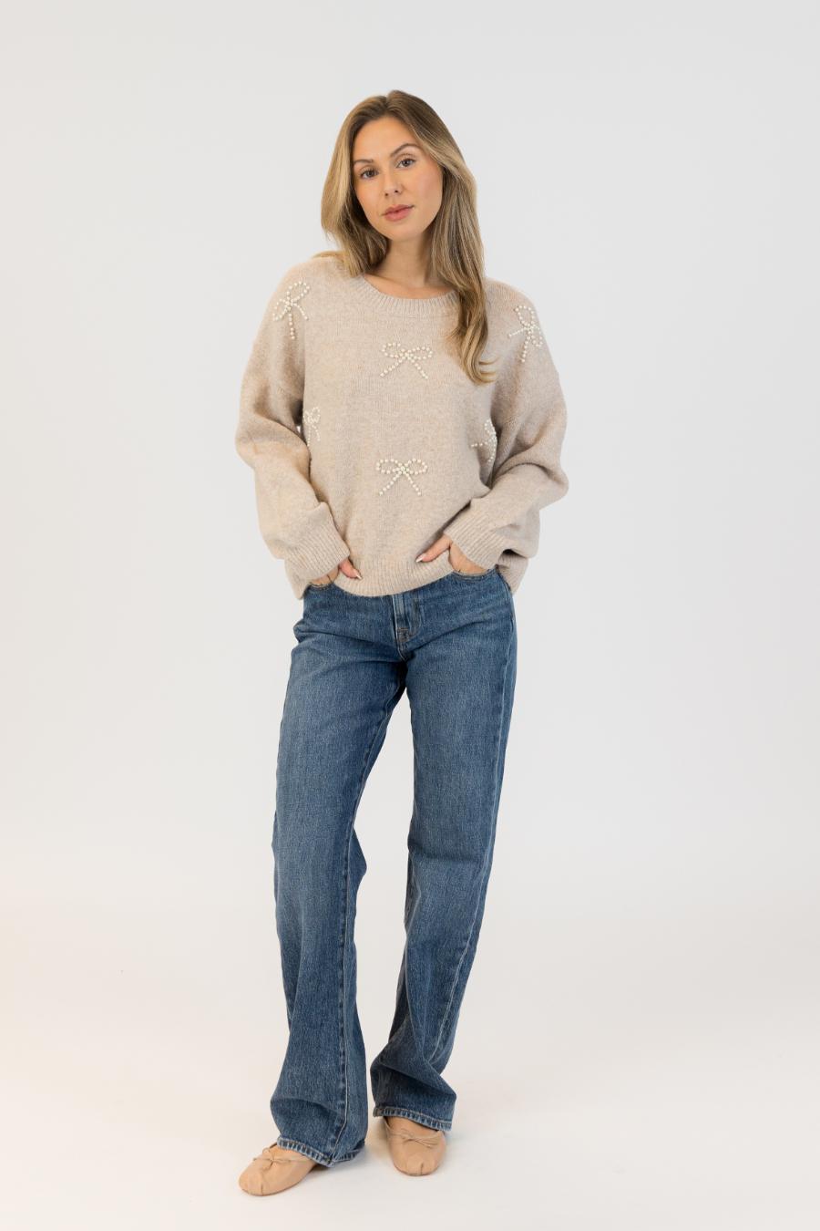 beige sweater with bows on it