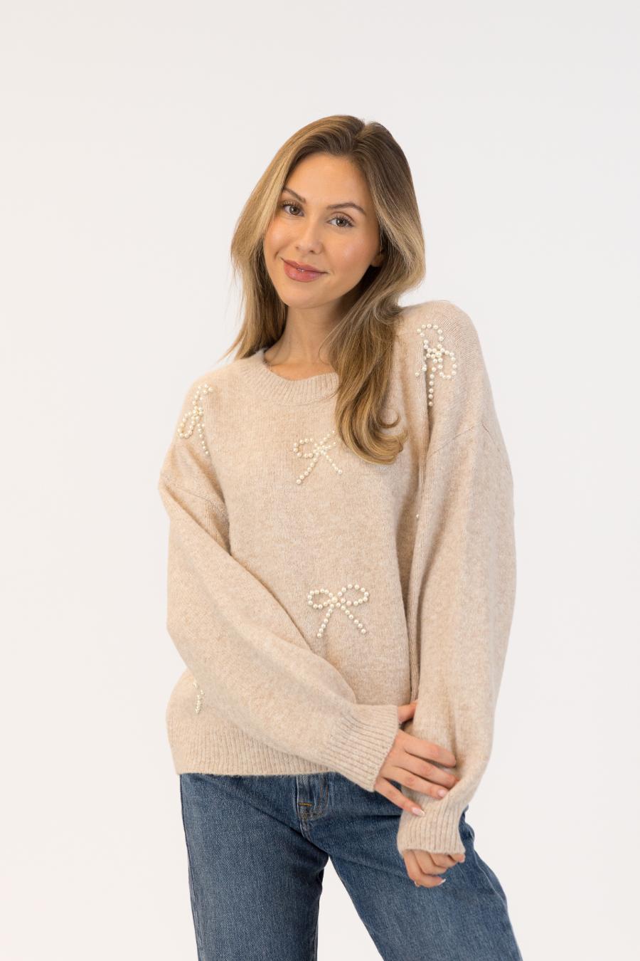 beige sweater with bows on it