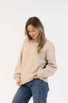 beige sweater with bows on it