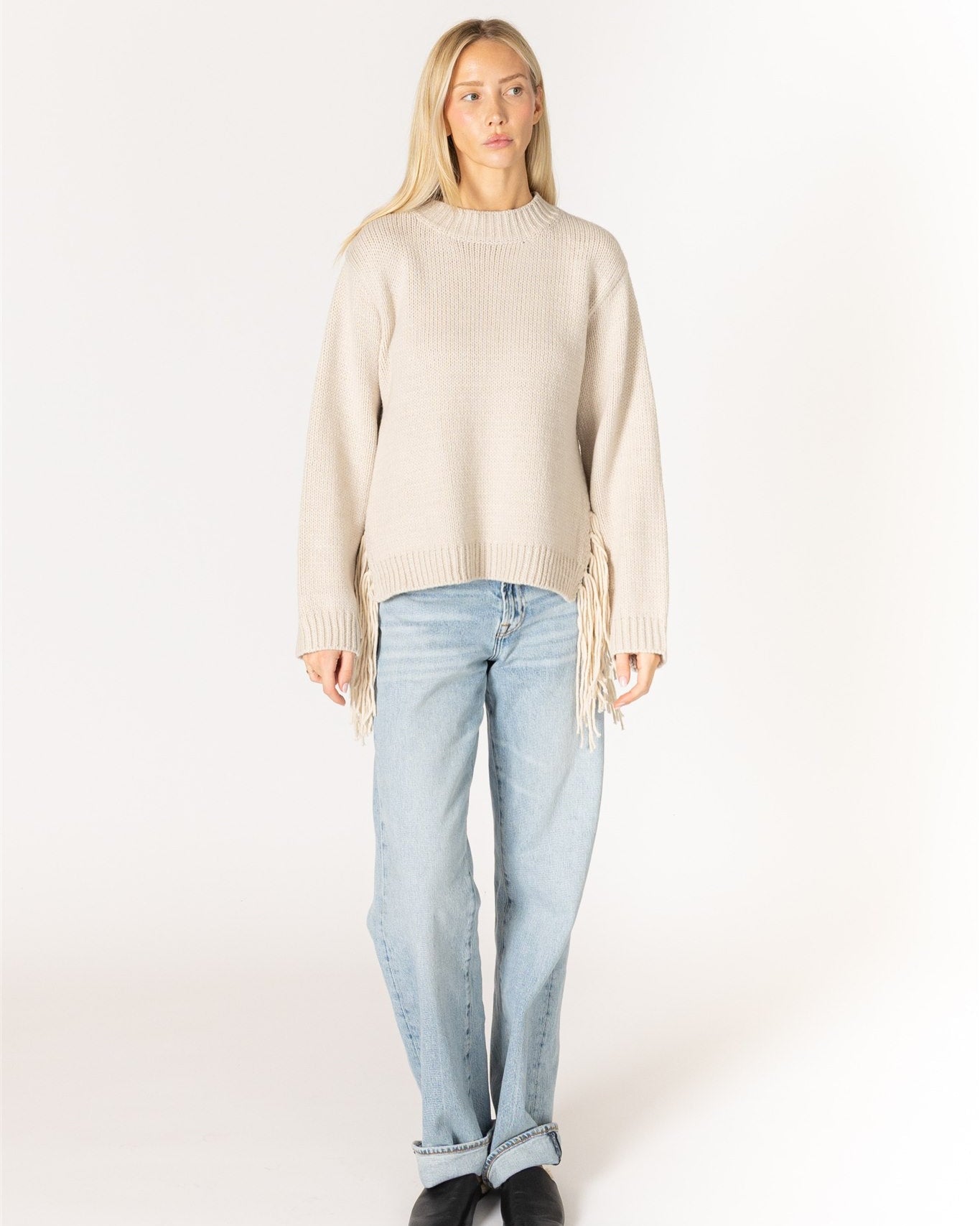 beige knit sweater with tassels on the sides