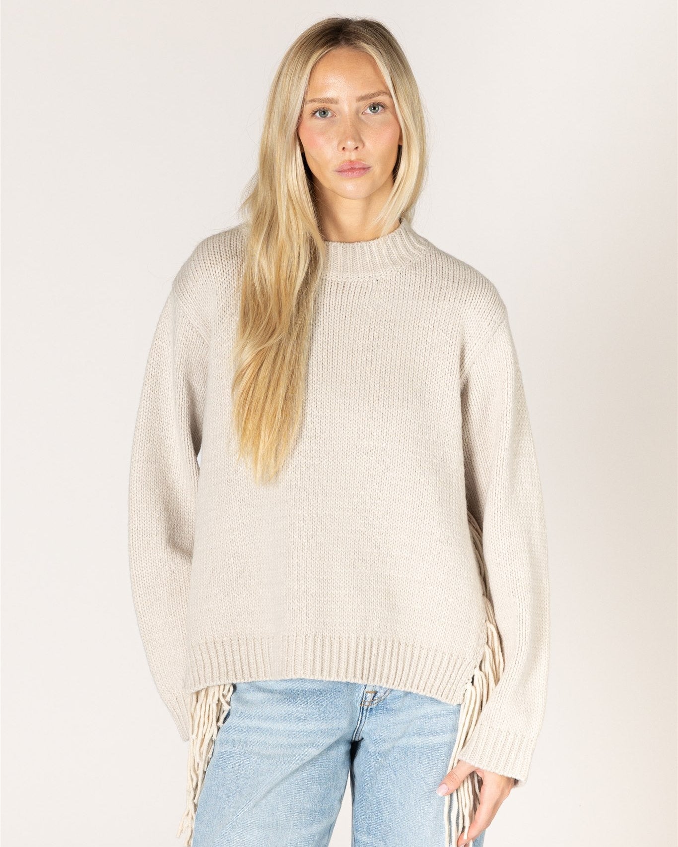 beige knit sweater with tassels on the sides