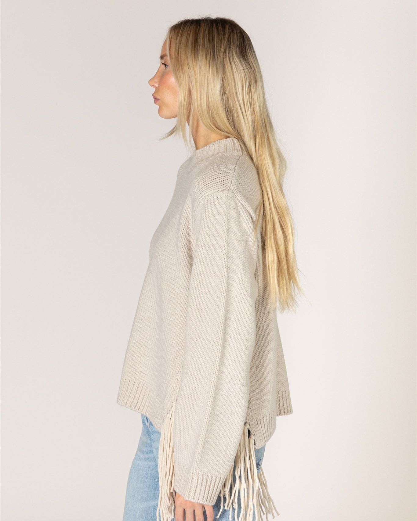 beige knit sweater with tassels on the sides