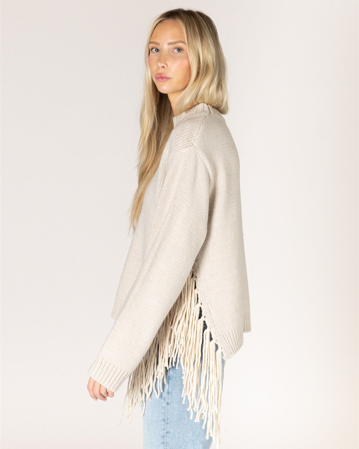 beige knit sweater with tassels on the sides