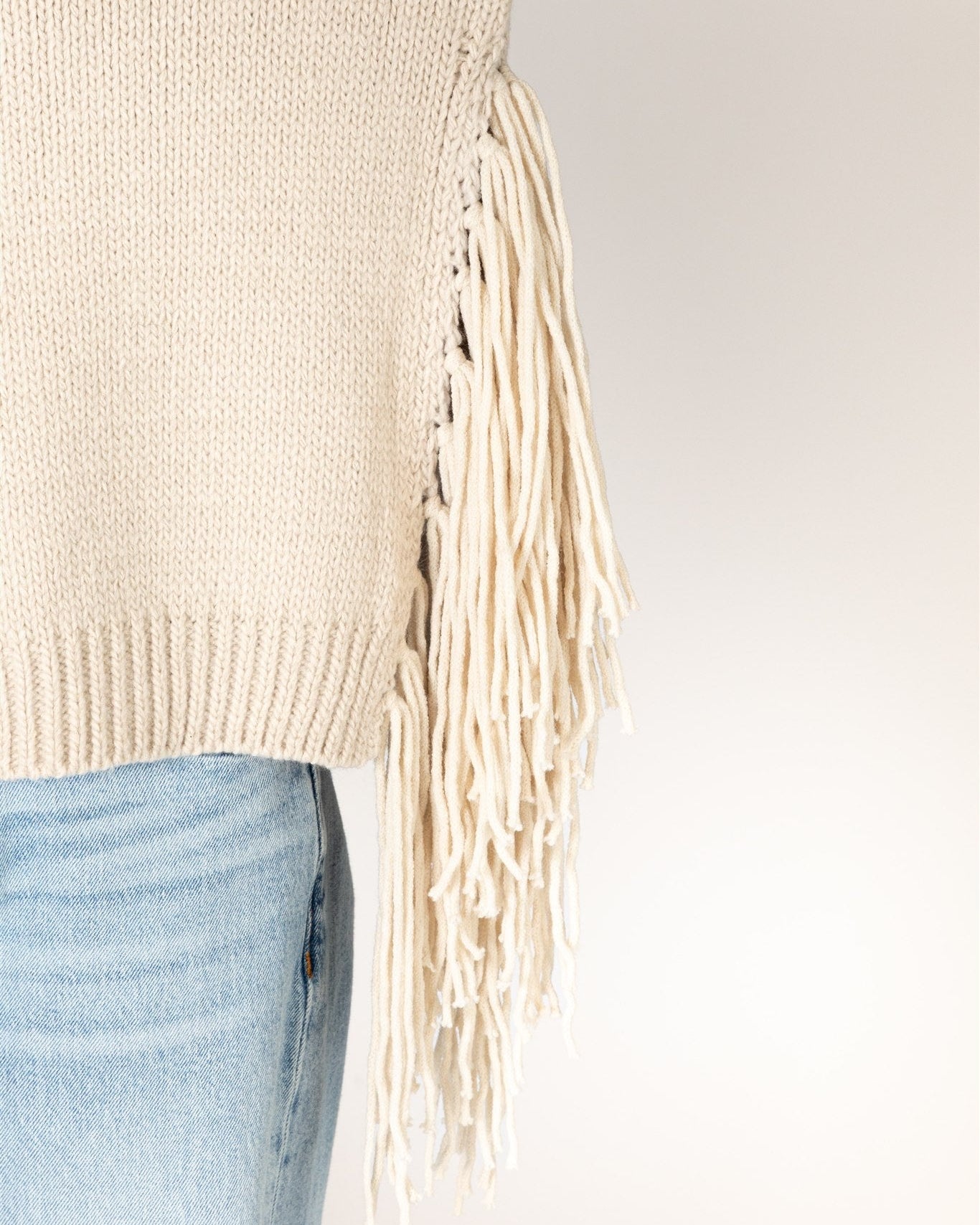 beige knit sweater with tassels on the sides