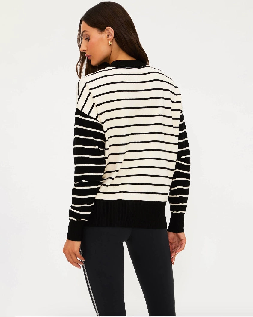 Woman wearing a black and white striped sweater with 'SKI' written on it