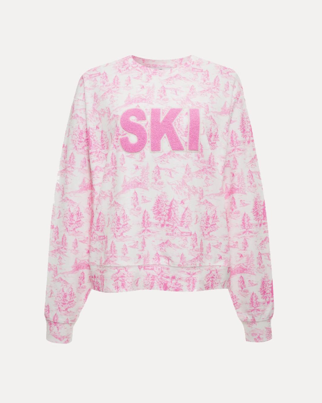 a woman wears a sweatshirt in white with pink toile ski pattern with the words 'SKI' on it