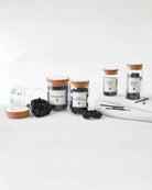a set of glass jar gift sets for haircare including a glass jar of black satin scrunchies for gifting