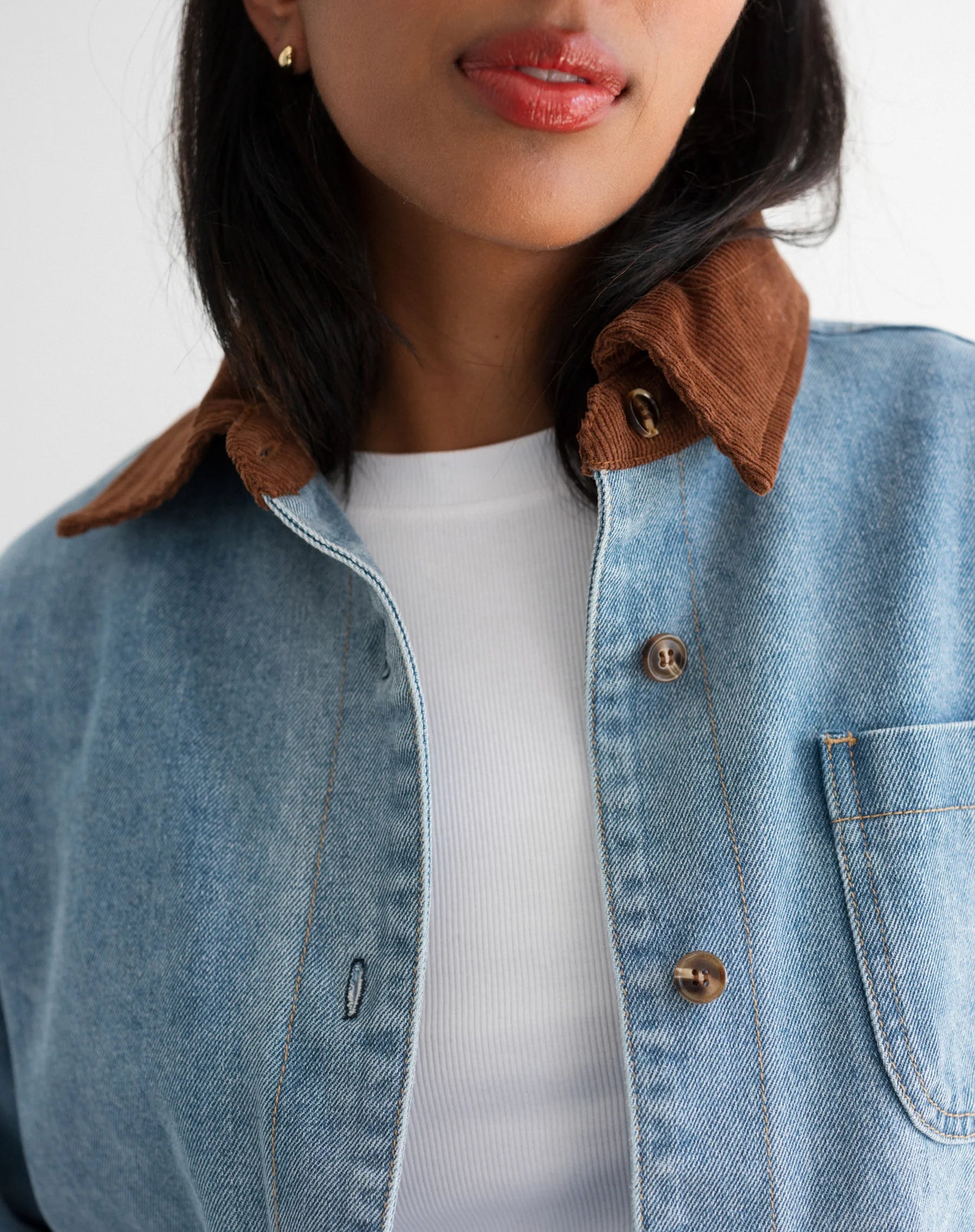close up of woman wearing denim jacket with brown corduroy collar